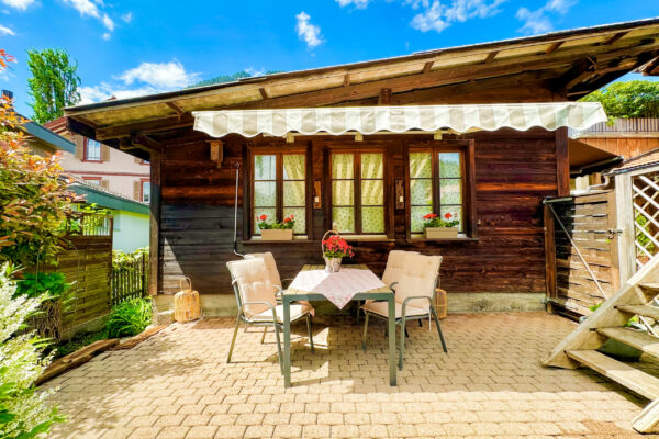 Chalet Simmi-28 Das Chalet Simmi von außen: ein einladender Sitzbereich mit Tischbedeck lädt zu schönen Stunden im Freien ein