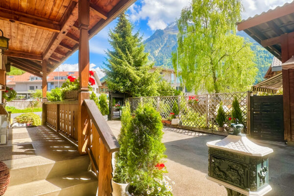 Chalet Simmi-41 Das Chalet Simmi von außen: ein wunderschöner Eingang, grüne Bäume vor einem blauen Himmel