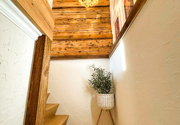 680362227 Chalet Simmi Stiegen im warmen Licht mit Lampe und Dekopflanze